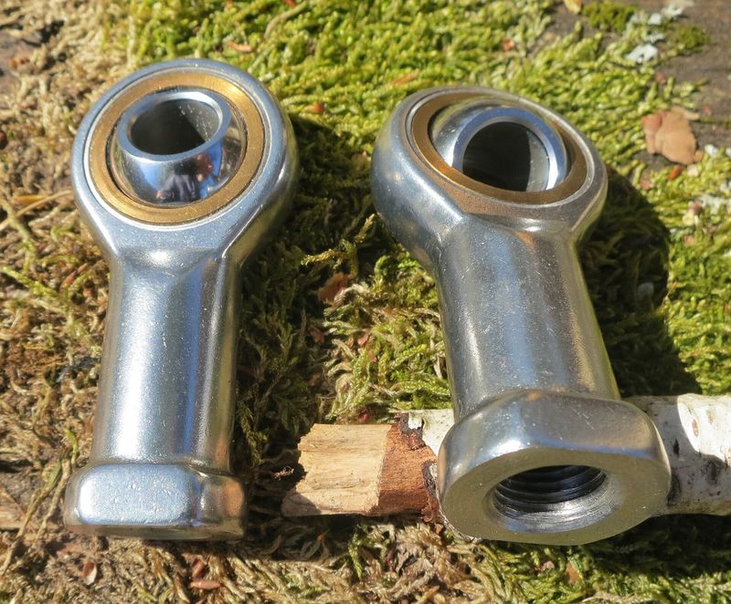Two steel rod end bearings (Heim-style joints) with threaded shanks